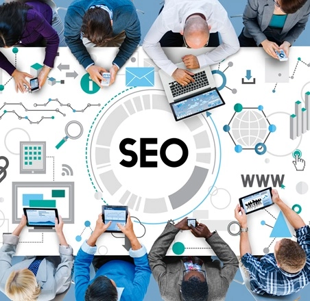 SEO written table surrounded by professionals using laptops,tablets and mobilephones
